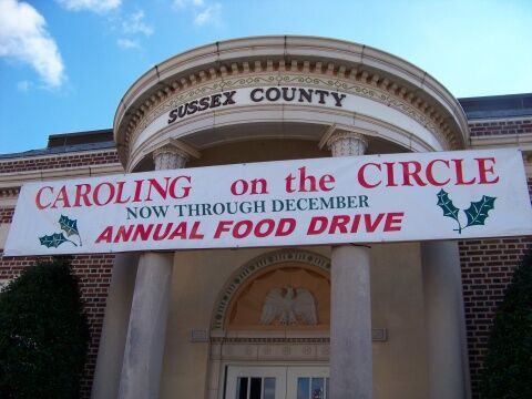 Caroling on The Circle food drive banner